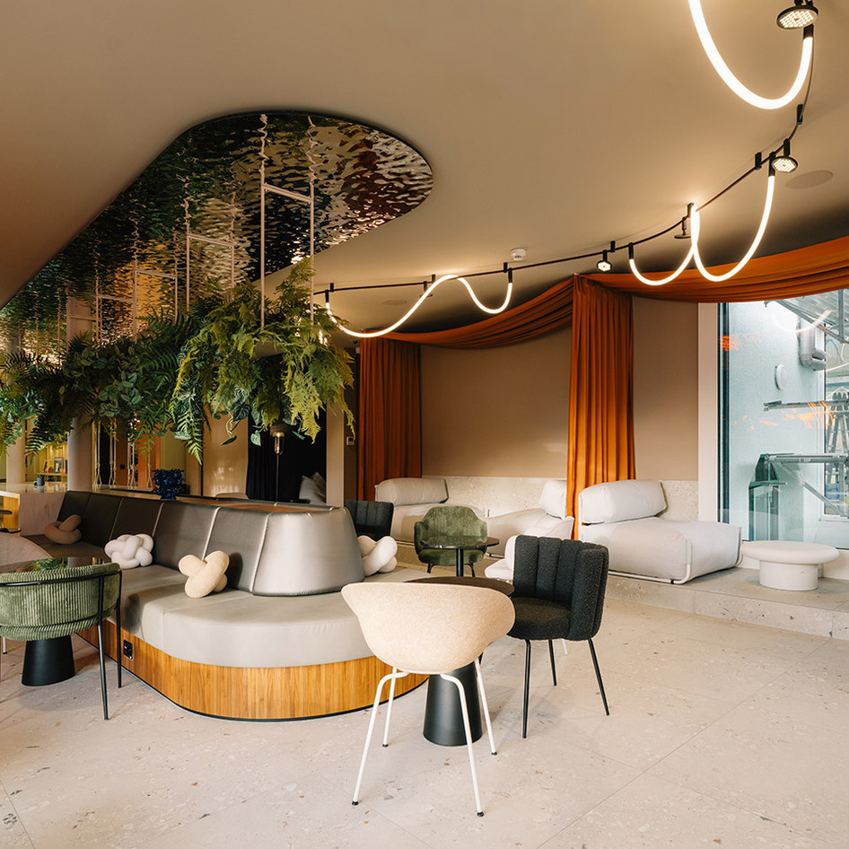 Contemporary lounge with Sylt ceiling system, curved luminous elements, Helgoland and hanging plants.