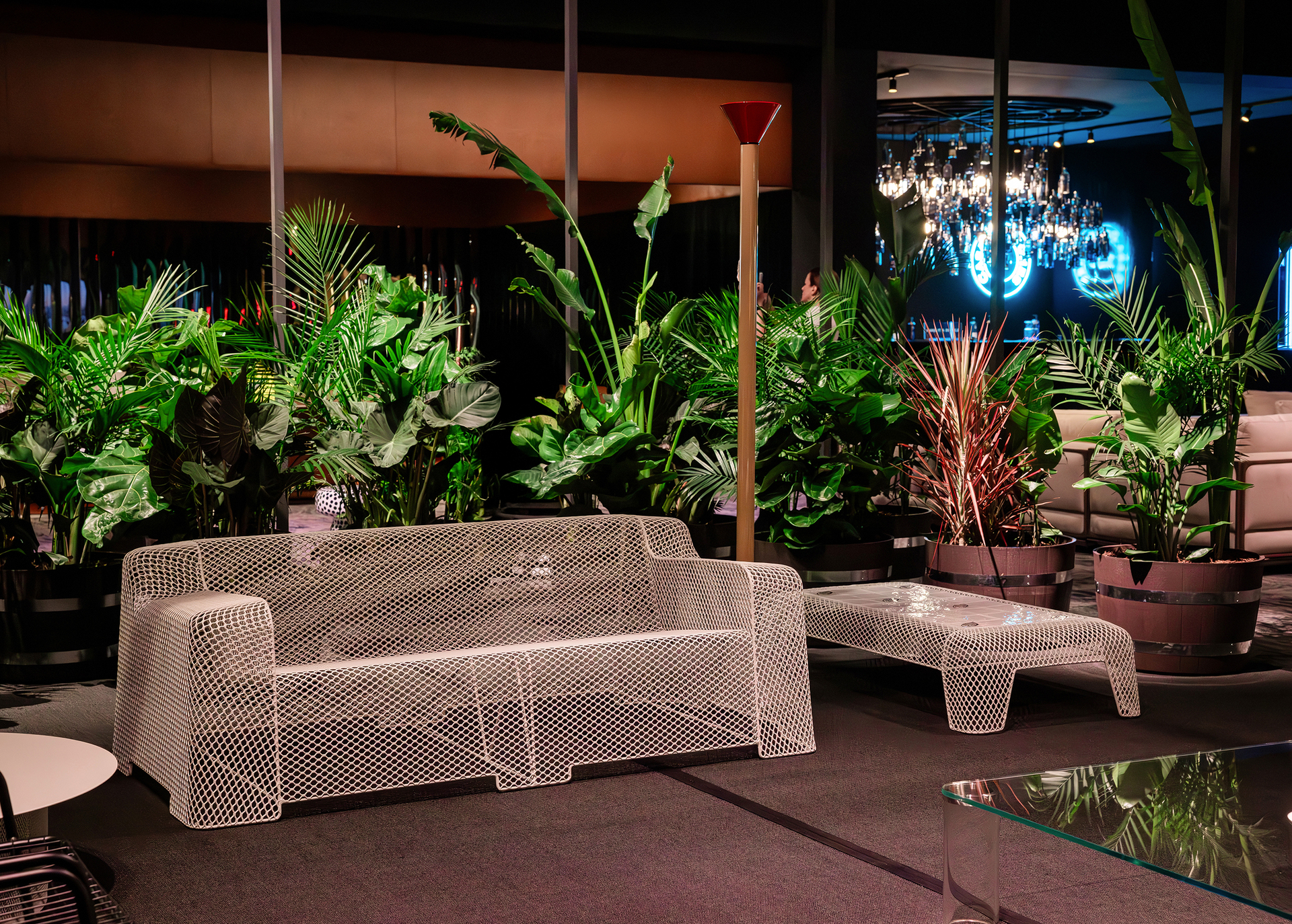 Installation view of the Salone del Mobile.Milano Collectors Lounge at Art Basel Miami Beach, featuring a living area with sofa, side table and Callimaco lamp by Artemide; plants in the background frame the space.