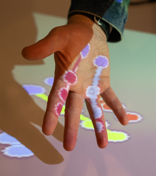 Image of a hand illuminated by colours.