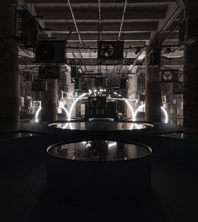Symbol of Michelangelo Pistoletto's Third Paradise recreated with Artemide's Linea, in a room with water mirrors reflecting its shape.