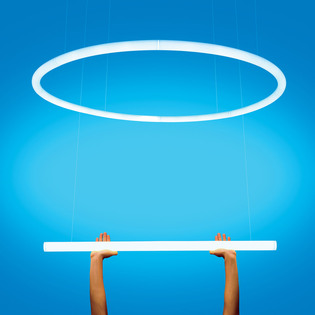 Circular and linear Alphabet of Light suspension held by two hands against a light blue background. Photo by Pierpaolo Ferrari.