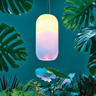 Gople Outdoor pendant lamp among large tropical leaves against a deep teal background. Photo by Pierpaolo Ferrari.