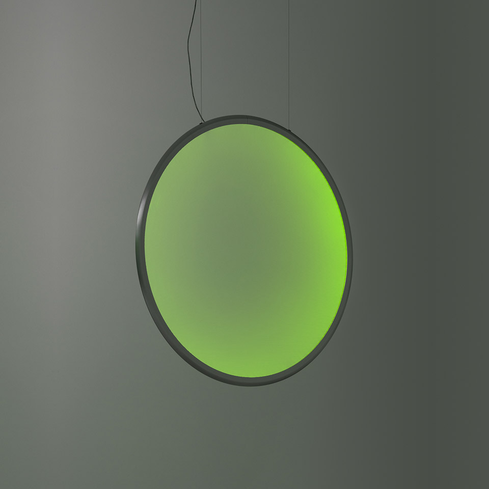 Artemide Discovery pendant lamp: large circular disc emitting vibrant green light, dark metal frame, suspended by thin black cable