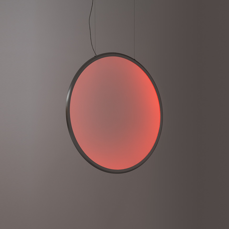 Artemide Discovery pendant lamp: large circular disc with dark frame emitting warm red-pink gradient light, suspended by black cord - 2