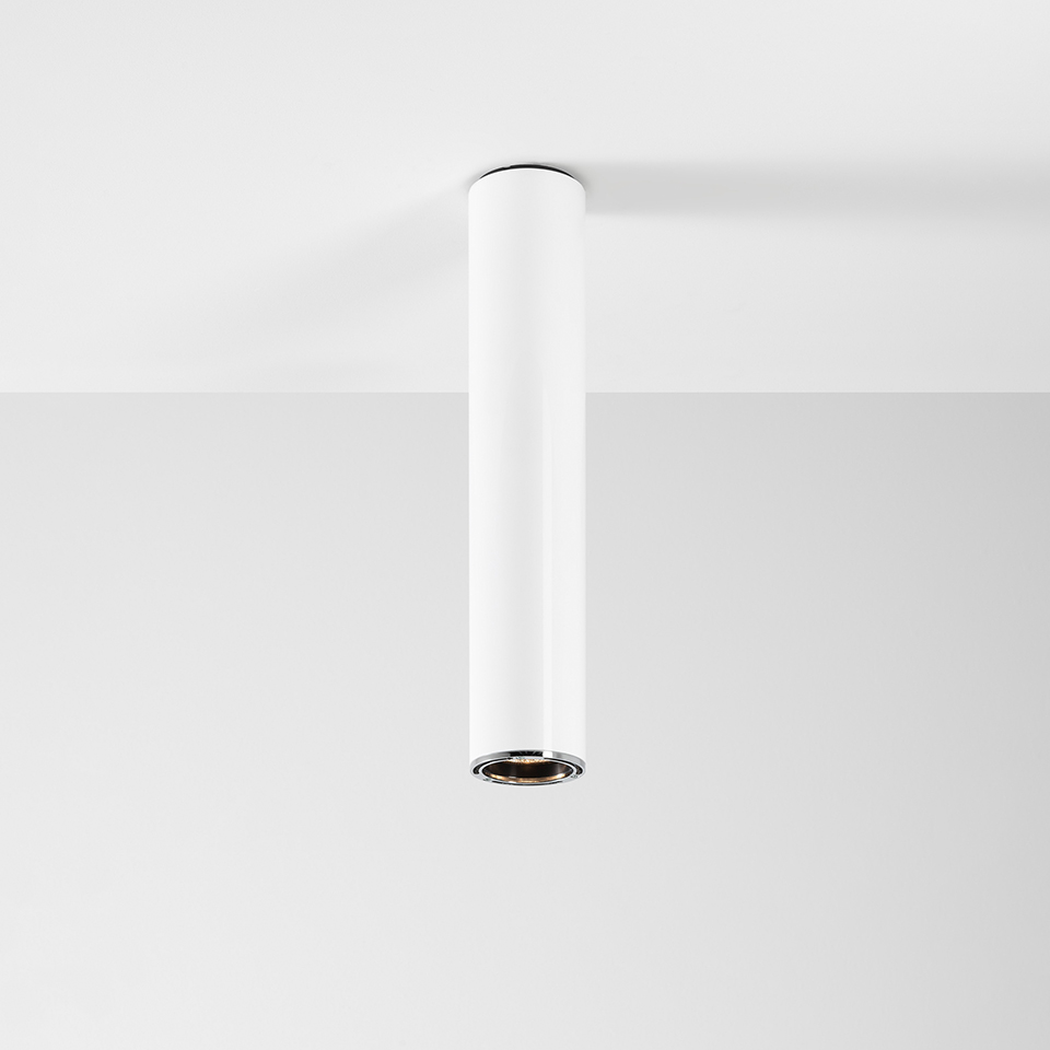 Artemide Ilio ceiling spotlight: slim white cylindrical body surface-mounted, with recessed LED head and chrome inner ring