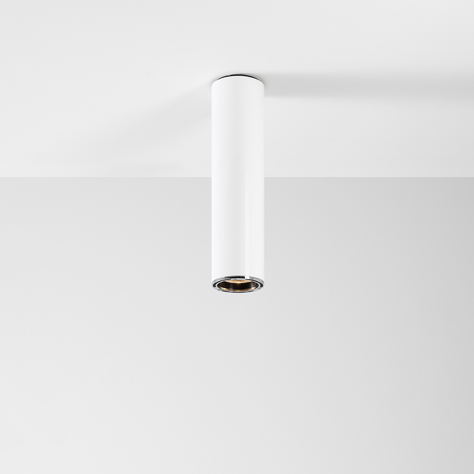 Artemide Ilio ceiling spotlight: white cylindrical body with chrome inner ring, surface-mounted downlight for directional lighting
