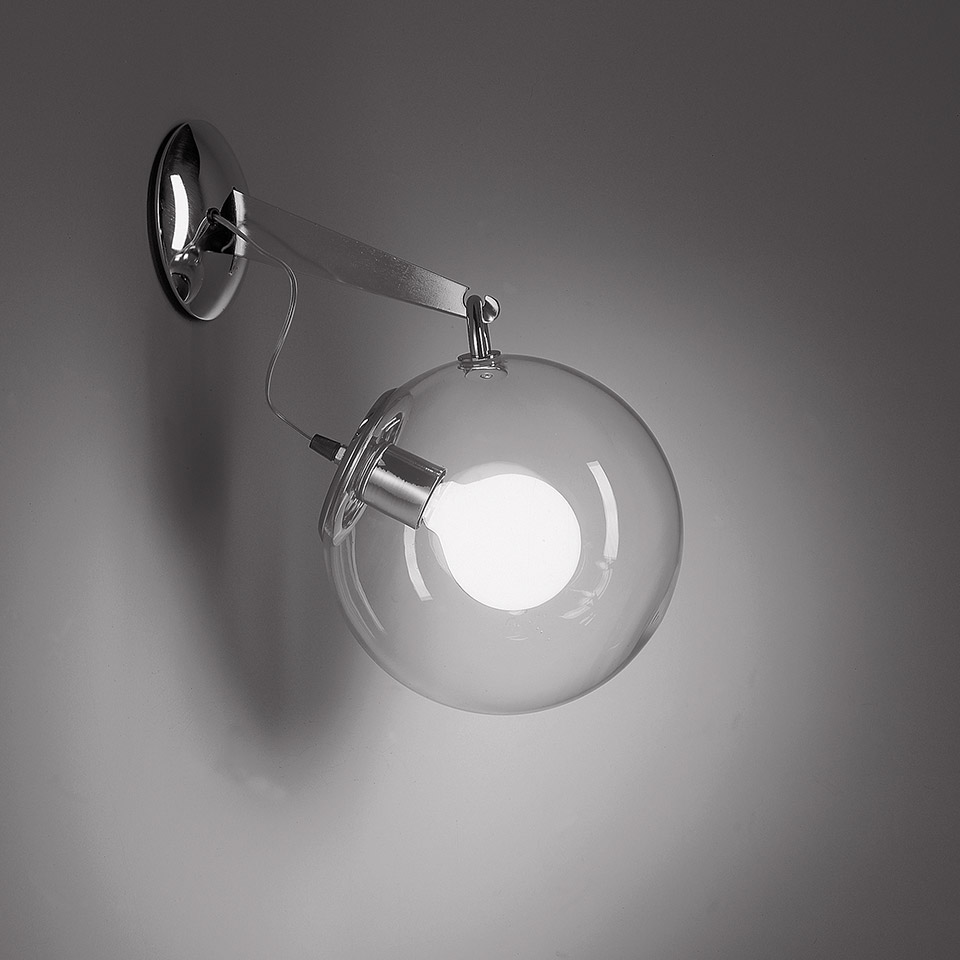 Artemide Miconos wall lamp: chrome arm on wall mount supporting a clear spherical glass globe with illuminated bulb
