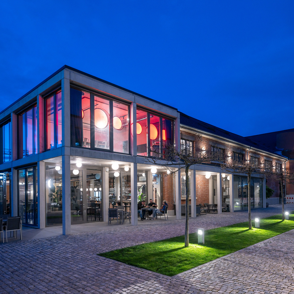 Image of the outside of the event venue, the veranda lit by Dioscuri Ceiling and inside you can see a series of Discovery Vertical.
