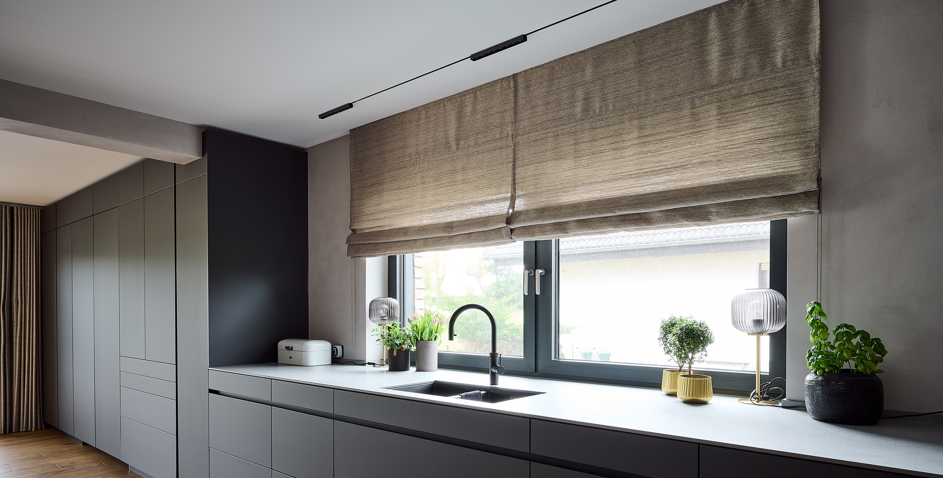 Linear kitchen with dark gray cabinetry, a large window above the worktop, and Turn Around lighting.