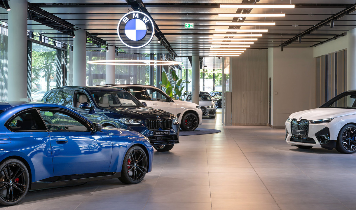 Interior of the BMW branch with multiple vehicles lined up, illuminated by Alphabet of Light Circular and Linear.