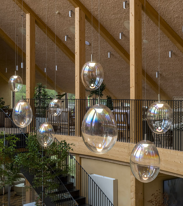 Cluster of Stellar Nebula pendants illuminates the large timber atrium designed by BIG.