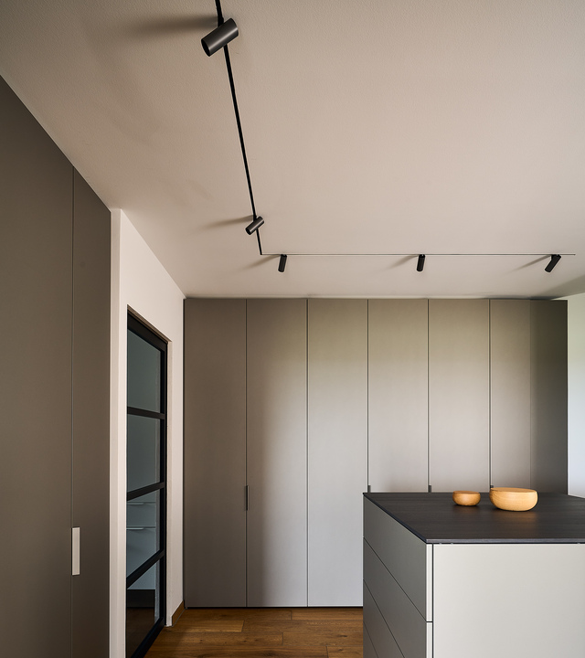 Modern kitchen with taupe-gray cabinets, wooden flooring, and the Turn Around lighting system on the ceiling.