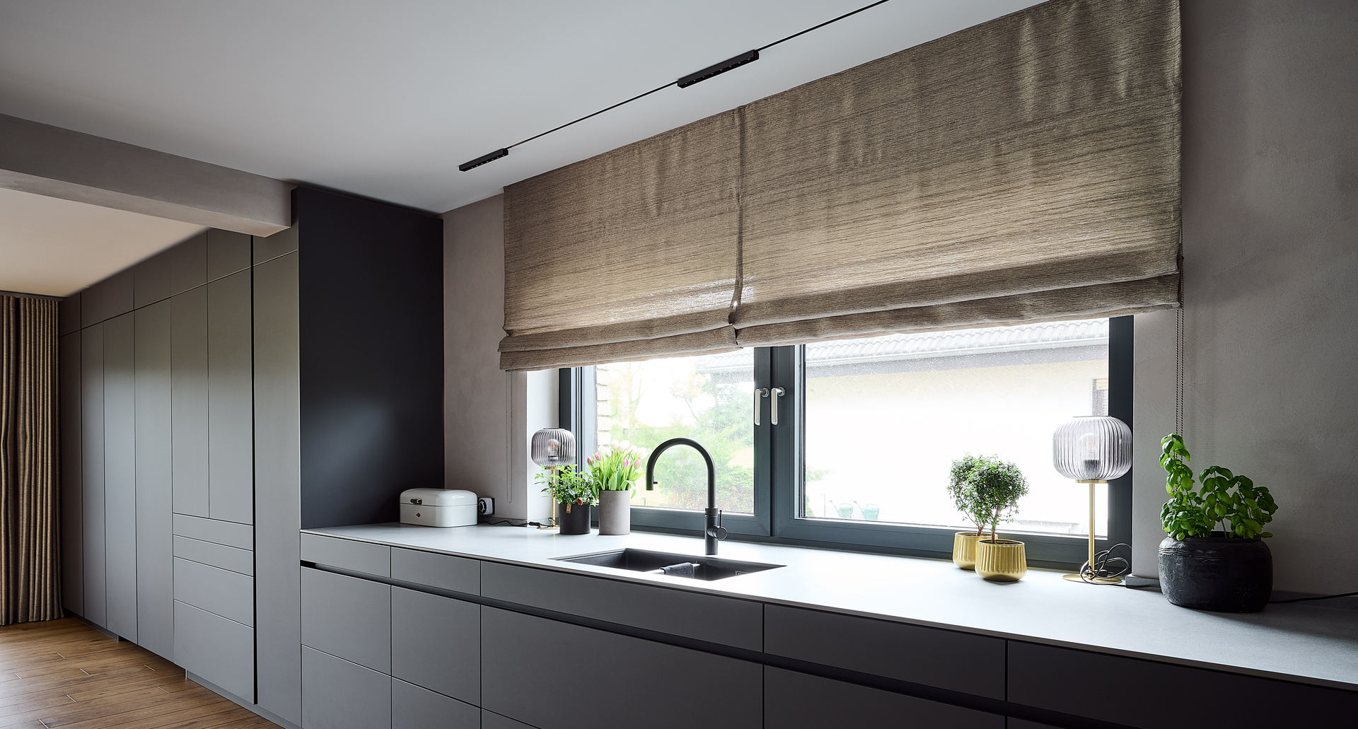 Linear kitchen with dark gray cabinetry, a large window above the worktop, and Turn Around lighting.