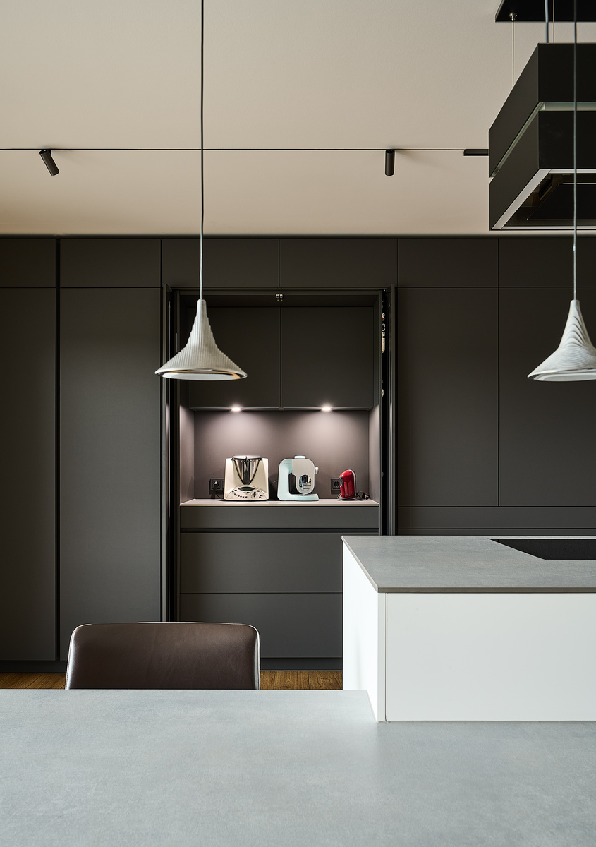 Kitchen detail with a light island, dark cabinets, pendant lights, and Turn Around lighting.